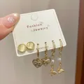 Three-pair gold earring set with yellow cat-eye stone, heart pendant, and pearl butterfly - Heart Butterfly Style