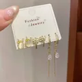 Three pairs of golden bow, rabbit opal, and tassel earrings set on display card - Cat Eye Rabbit Style