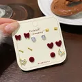 Set of 7 pairs red flocked heart and butterfly stud earrings on cream display card - Seven Pair Pack / Red Heart Butterfly Style