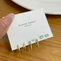 Dreiteiliges goldenes Ohrring-Set mit glatten Reifen, Pavé-Huggies und Steckern - Polierte Und Strass-Stile / Gold