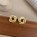 Elegante goldene Knoten-Ohrstecker für Damen mit strukturiertem Metalldesign auf Holz - Gold