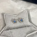 Orecchini a perno a stella con zircone blu mare e finitura in oro bianco - Paio / Fiore in zirconia blu