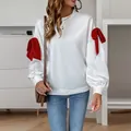 Detalle de sudadera blanca con lazos rojos en las mangas largas y puños acanalados - S / Blanco