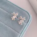 Silver bow and ballet slipper stud earrings displayed on light blue velvet tray - Ballet Ribbon Shoes