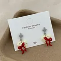 Elegante cremefarbene Herzohrringe mit roter Schleife und goldenen Punkten - Design Schleife Herz Stil