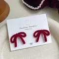 Elegant red velvet bow stud earrings on a fashion display card with pearl accents - True Red Bowknot (RV19)