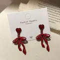 Elegant deep red heart earrings with a ribbon bow design on a vintage background - Twist Bow Heart Style