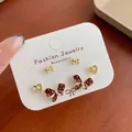 Three-pair set featuring red polka dot bows and golden pearl earrings on jewelry card - Red Bow Polka Dot (BN10)