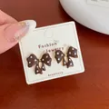 Elegant brown polka dot bow stud earrings with gold center on a display card - Brown Polka Dot Bow (BN12)