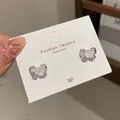 Elegante Schmetterlingsstecker in Silber mit irisierenden Kristallen und kleiner Perle - Funkelnde Schleife