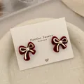 Elegant red velvet bow stud earrings with a gold border and center pearl detail - Vertical Gold Bowknot (RV24)
