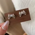 Elegante silberne Schleifenohrstecker mit weißer Perle und hohlen Wabenmetalldetails - Mattsilberne Schleife mit Perlen (CF5)