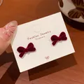 Elegant deep red flocked velvet bow earrings displayed on a white fashion jewelry card - Twisted Bowknot (RV33)