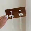 Elegant silver bow earrings with heart-shaped zircon and long tassel chains in polished finish - Party Bowknot