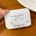 Three-pair silver butterfly and bow stud earring set on display card with sparkles - Butterfly Jewelry Set / Silver