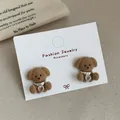Brown flocked bear stud earrings with heart crystal pendants on jewelry display card - Bear Hugging Zirconia (VF10) / Brown