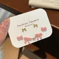 Three-pair set of sweet pink flocked bow and golden metal stud earrings on a display card - Pink Bowknot