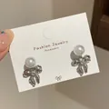 Elegante silberne Schleifenohrringe mit runder weißer Perle und Kristallakzenten - Perlenschleife