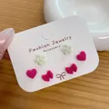 Three-pair earring set featuring red flocked bows, hearts, and white pearl flowers - Rose Red Heart