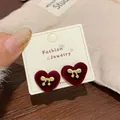 Elegant red flocked heart stud earrings with golden bow detail on a display card - Red Heart Bowknot (AXW47)