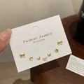 Minimalist gold stud earring set with butterfly and floral shapes on display card - Gold Flower Earring Set (JTZT004)