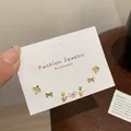Three pairs of small golden stud earrings featuring flower, bow, and tulip designs - Gold Tulip Earring Set (JTZT007)