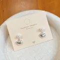 Silver bow stud earrings with white pearl and hanging heart charms on jewelry card - Pearl Heart Design