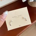 Silver celestial bow earrings with crescent moon and star charms on display card - Silver Shooting Star