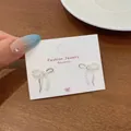 Silver bow dangle earrings featuring white pearls and rose details on a jewelry card - Bowknot with Pearl