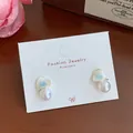 Blue heart earrings with bow detail and white pearl drops on display card - Pearl Blue Heart (YRH2)