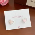 Pink heart stud earrings with silver borders and shimmering finish on a jewelry card - Pearly Pink Heart (YRH4)