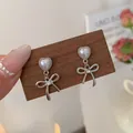 Silver bow earrings with heart pearl studs and sparkling crystal accent - Hollow Bowknot