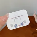 Coffret de boucles d'oreilles papillon, fleur émaillée et perle sur carte - Papillon Floral Violet Bleu
