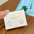 Sparkling starfish earrings with iridescent finish and pearl-like glow on card - Dazzling Blue Star Studs