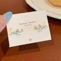 Playful polka dot dachshund stud earrings with light blue clothing on a display card - Blue Clothes Dachshund Stud Style