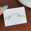 Cute polka dot dachshund earrings with cream body and blue bow on a jewelry card - White Pearl Dachshund Drop Style