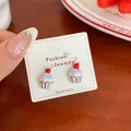 Kawaii-Ohrstecker in Cupcake-Form in Rosa und Blau auf einer Schmuckkarte - Kirsche Cupcake Stil