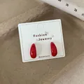 Glossy cherry red teardrop stud earrings on white card display, vintage minimalist style - Large Red Waterdrop C-Shaped Hoop (REW2)