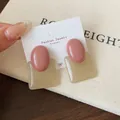 Pink oval and translucent brown square geometric resin stud earrings on a display card - Pink Round Square Studs