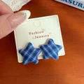 Navy blue plaid star-shaped fabric stud earrings displayed on a jewelry card - Blue White Plaid Star