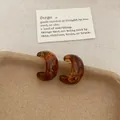 Amber tortoiseshell resin C-shaped hoop earrings with retro aesthetic on a paper tray - Amber Texture C Ring