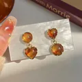 Amber resin heart and circle earrings with gold metal frame on a display card - Heart Round Irregular Earrings