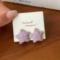 Star-shaped fabric earrings with purple and khaki checkerboard pattern on wood background - Purple Brown Plaid Star