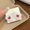 White plush heart stud earrings with cute red ribbon bow on display card - White Bowknot Heart