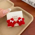 Red plush star earrings with silver bow accent on jewelry card display stand - Red Bow Star