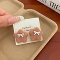 Brown fuzzy star earrings with silver bow detail on fashion jewelry display card - Brown Bow Star