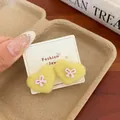 Yellow heart plush earrings with purple bow details on white display card - Yellow Bow Heart