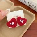 Red heart wool felt stud earrings with pink bow detail on jewelry card - Red Bow Heart