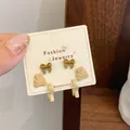 Three-piece brown bear and bow earring set with silver pins on a fashion display card - Bow Cookie Bear (QDT10)