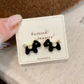 Chic black flocked puppy stud earrings with gold accents on a display card - Black Dog Earrings (MMW36)